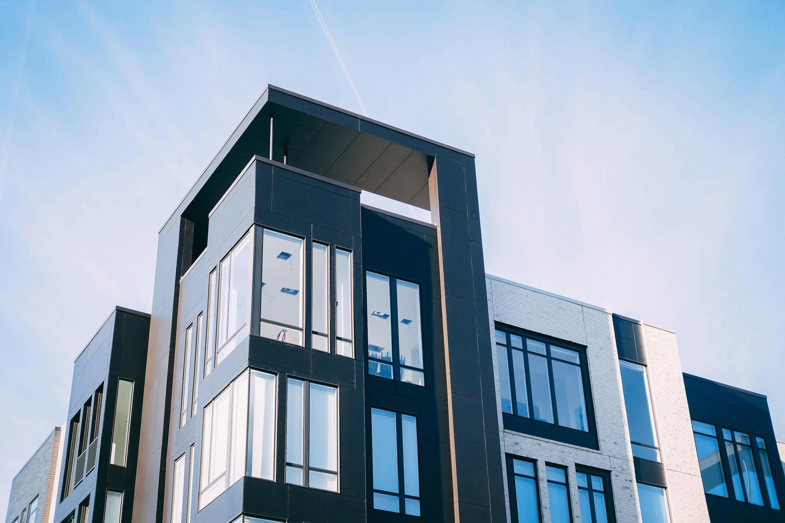 Modern multi-storey building with black and white exterior against a blue sky